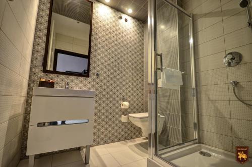 uma casa de banho com um WC e uma cabina de duche em vidro. em CTKiR Browar Probus em Olawa