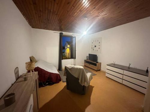 Cette chambre comprend un lit et une horloge murale. dans l'établissement Appartement à Jarny Gare, à Jarny