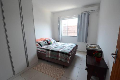 a small bedroom with a bed and a window at Casa Campeche 5 minutos, a Pé, da Praia in Florianópolis