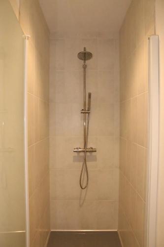 une douche avec pommeau de douche dans une salle de bain dans l'établissement Magnifique appartement - Hyper centre Vieux Cognac, à Cognac