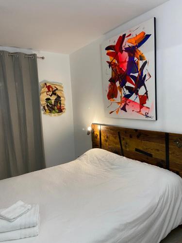 une chambre avec un lit et un tableau au mur dans l'établissement La Chambre du Patio, au Luc