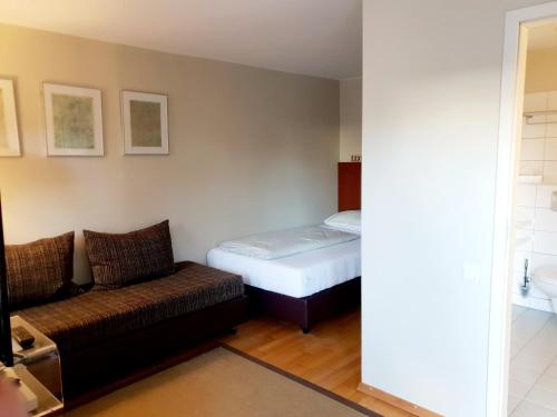 a small room with a bed and a couch at Hotel Fährhaus GmbH in Woltersdorf
