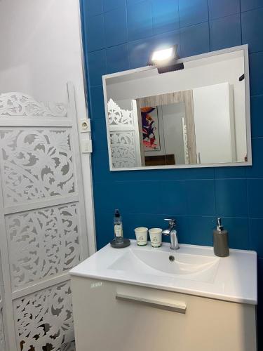une salle de bain avec un lavabo blanc et un miroir dans l'établissement La Chambre du Patio, au Luc