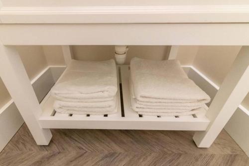2 toallas plegadas en un estante bajo un lavabo en AmishGuestCottage~cozystudio~hottub~patio, en Gordonville