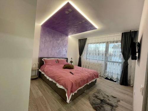 - une chambre avec un grand lit et un plafond violet dans l'établissement D&D New Residence, à Piteşti