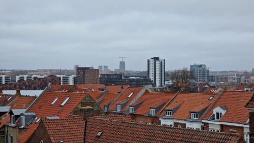 a view of roofs of houses in a city at Center apartment - top floor penthouse with views of the city in Aarhus