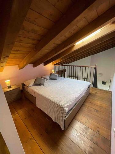 a large bed in a room with a wooden floor at Appartamento vicino Forum Assago & Humanitas in Rozzano