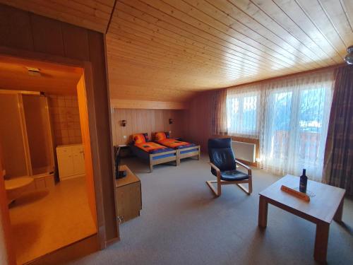 a room with a bed and a chair and a table at Chalet Tamara in Riederalp