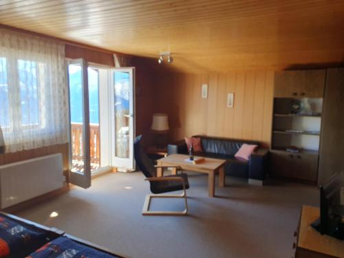 ein Wohnzimmer mit einem Sofa und einem Tisch in der Unterkunft Chalet Tamara in Riederalp