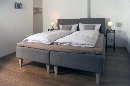 a bed with white sheets and pillows on it at Ferienwohnung Seidl Wohnung Violine in Mittenwald