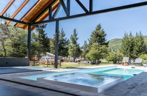 una gran piscina con techo de cristal y una piscina en La Finca Hostel de Montaña - Habitación Laguna en San Carlos de Bariloche