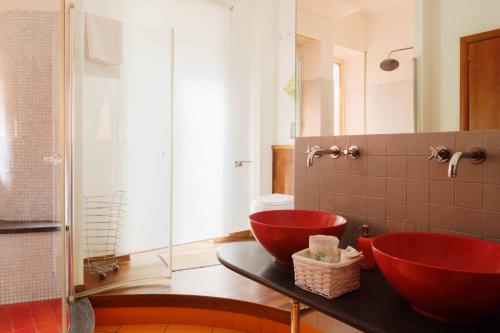 a bathroom with two red sinks and a shower at AmoCatania Apartment in Catania