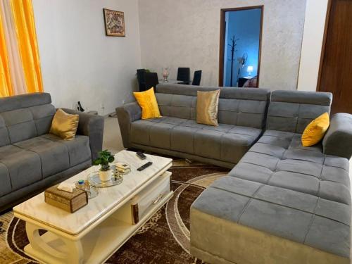 a living room with two couches and a coffee table at Studio meublé Corniche Mermoz in Dakar