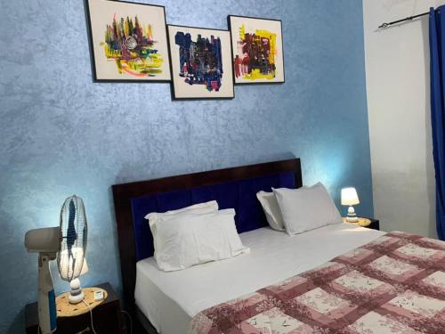 a bedroom with a bed with four pictures on the wall at Studio meublé Corniche Mermoz in Dakar