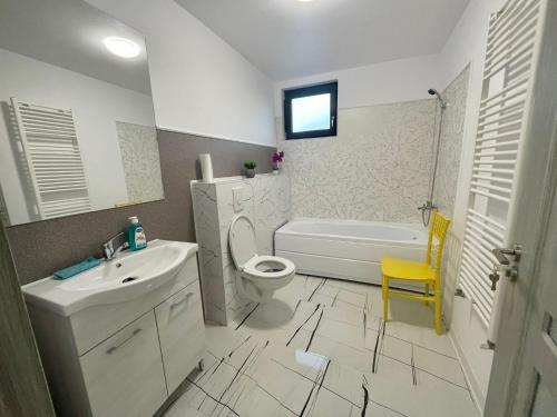 a bathroom with a sink and a toilet and a tub at D&D New Residence in Piteşti