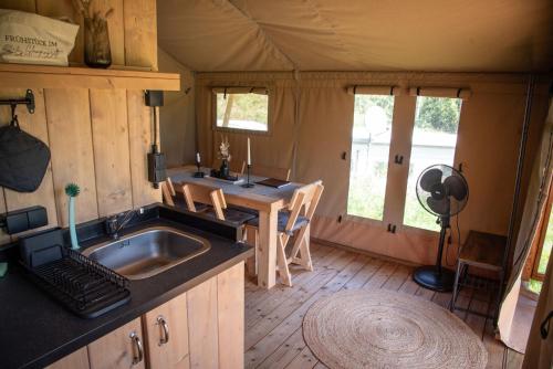 a kitchen with a sink and a table in a tent at Glampingzelt Heide - Lodge in Soltau