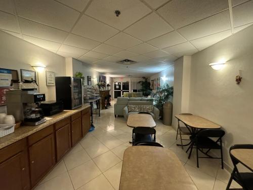 una zona de espera de un hospital con mesas y sillas en Emerald Shores Hotel - Daytona Beach, en Daytona Beach