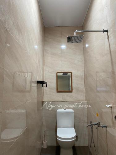 a bathroom with a toilet and a mirror at Najma guest house in Kota Bharu