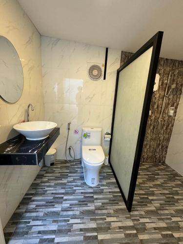 a bathroom with a toilet and a sink and a mirror at อิงภูเมาท์เท่นวิว เขาใหญ่ in Ban Khan Takhian