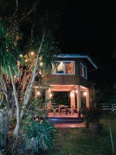 a house with palm trees and a patio at night at อิงภูเมาท์เท่นวิว เขาใหญ่ in Ban Khan Takhian