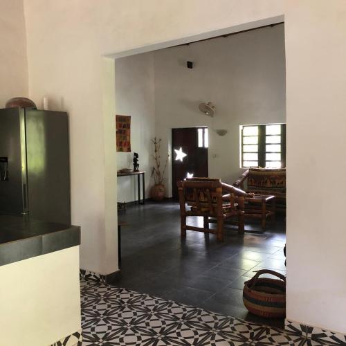 a kitchen and dining room with a table and chairs at Karamaluu Garden Lodge in Gunjur