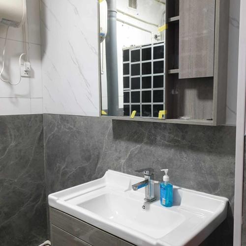 W łazience znajduje się biała umywalka i lustro. w obiekcie Bee happy Hostel w mieście Dalandzadgad
