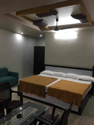 a bedroom with a bed and a table and chairs at Ajay Residency and Convention Hall / Lodge Near Me / Lodge Rayachoti in Rāyachoti
