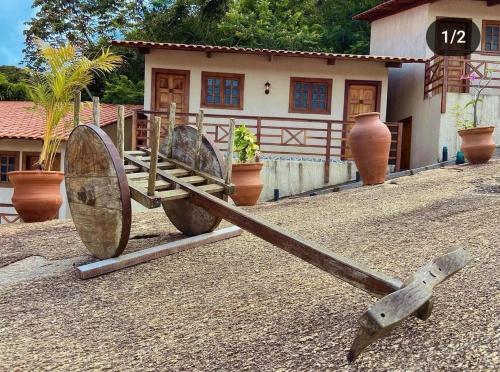 a large wooden instrument in front of a house at CHALES DA SERRA in Bananeiras