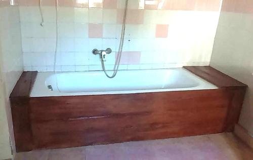 La salle de bains est pourvue d'une baignoire avec un tuyau. dans l'établissement Maison d'hôtes Villa Mont du Pèlerin à Toamasina Madagascar, à Toamasina