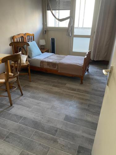 a bedroom with a bed and a table and chairs at Appartement 3 pièces pour 1 à 5 voyageurs in Rillieux