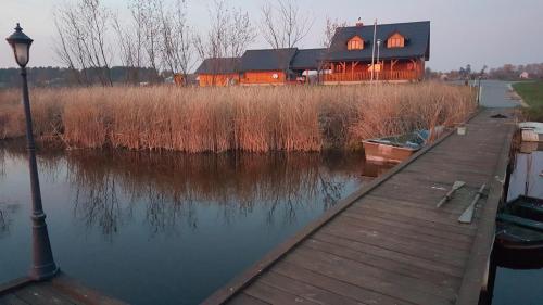 a house on the water with a dock and a boat at Dom wakacyjny Danielsja in Osiek