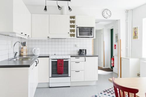 una cocina con armarios blancos y una toalla roja en Raftarp - Country side cottage in the woods en Sjöbo