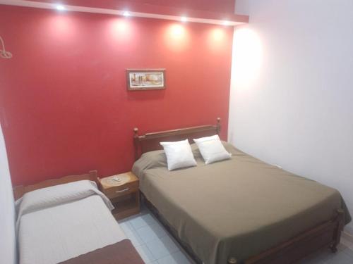 a bedroom with a bed and a red wall at Departamentos del Puerto Verde in Paraná