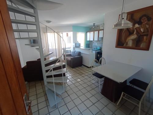 uma cozinha e uma sala de estar com uma escada num quarto em Dúplex mar de Pajuçara em Maceió