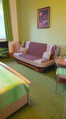 ein Wohnzimmer mit einem Sofa und einem Stuhl in der Unterkunft Penzion U Bernardýna in Tachov