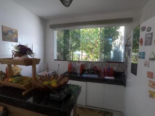 une cuisine avec une fenêtre et un comptoir avec des fruits dans l'établissement Casa Temporada em Praia Linda., à São Pedro da Aldeia