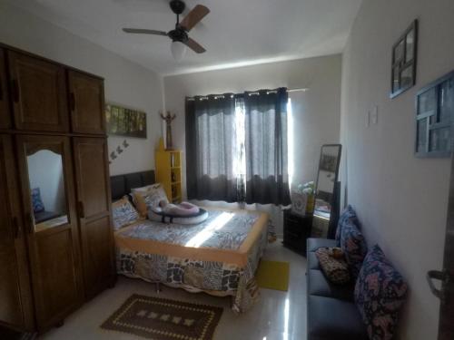 - une chambre avec un lit et un ventilateur de plafond dans l'établissement Casa Temporada em Praia Linda., à São Pedro da Aldeia