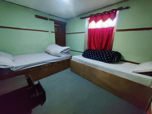 ein kleines Zimmer mit 2 Betten und einem Fenster in der Unterkunft Hotel Sambriddhi & Lodge in Tibrikot