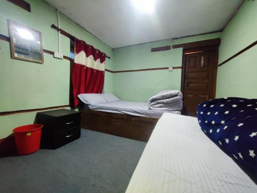 Zimmer mit 2 Betten, einer Tür und einem Fenster in der Unterkunft Hotel Sambriddhi & Lodge in Tibrikot