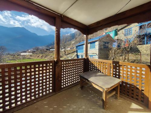 eine Bank auf einem Balkon mit Bergblick in der Unterkunft Hotel Sambriddhi & Lodge in Tibrikot