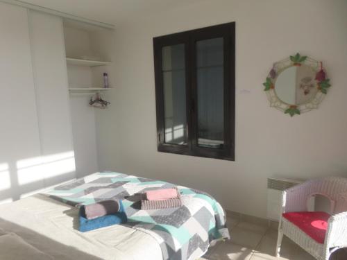 een slaapkamer met een bed met een deken en een spiegel bij Gruissan Village APPT Duplex 51m2 in Gruissan