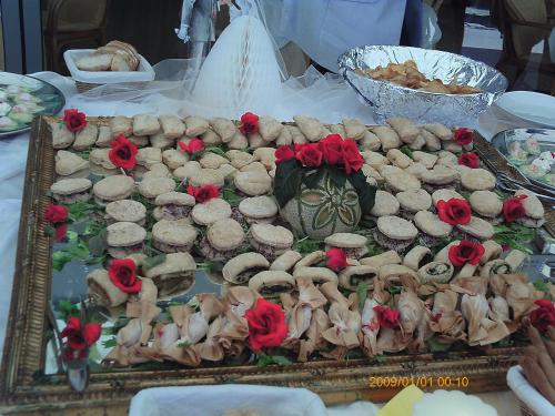 a table with a tray of cookies and red roses at Beach Hotel Du Lac Malcesine in Malcesine