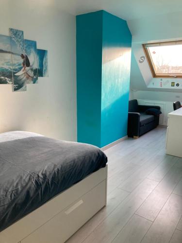 a bedroom with a bed and a blue wall at La Maison des Massena in Noisy-le-Grand