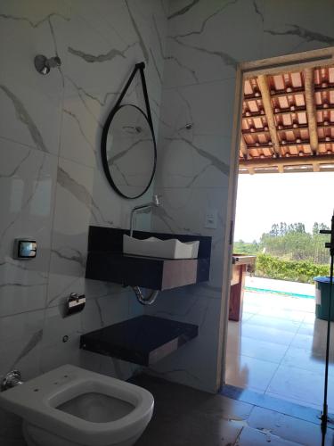 皮奧伊的住宿－Rancho Moreira，浴室设有卫生间和墙上的镜子。