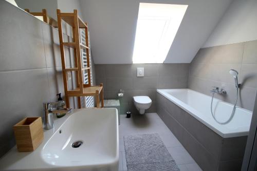 a bathroom with a sink and a tub and a toilet at Bodden Perle in Dierhagen