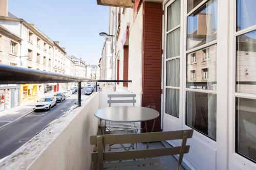 une table et des chaises sur le balcon d'un bâtiment dans l'établissement Royale - Hypercentre, à Orléans