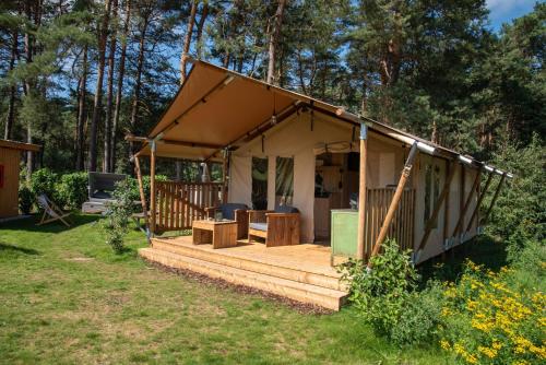 a small house with a deck in the yard at Glampingzelt Heide - Lodge in Soltau