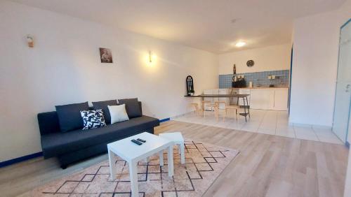 un salon avec un canapé et une table dans l'établissement Hébergement du Bourg, à Lourdes