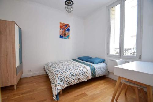 a bedroom with a bed with blue pillows on it at Maison de ville haut de gamme En face du stade de France in Saint-Denis
