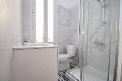 a white bathroom with a shower and a toilet at Maison de ville haut de gamme En face du stade de France in Saint-Denis